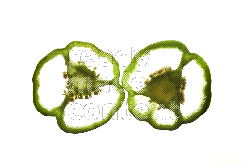 Green bell pepper slices on illuminated white background