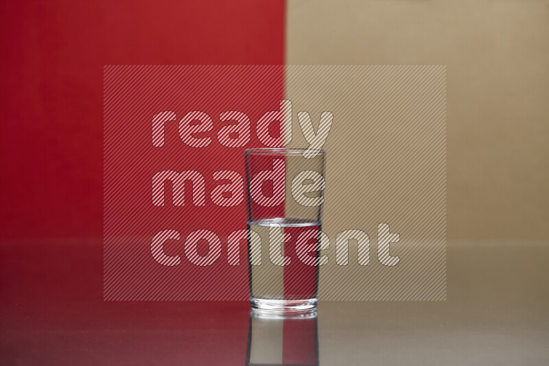 The image features a clear glassware filled with water, set against red and beige background