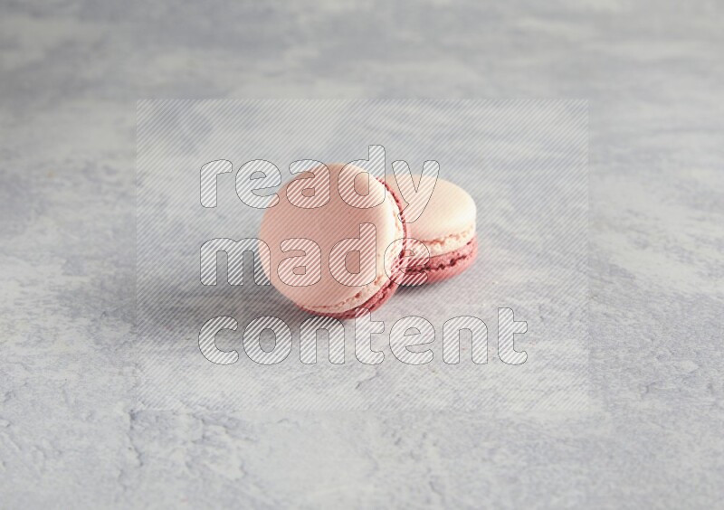 45º Shot of two Pink Litchi Raspberry macarons  on white  marble background