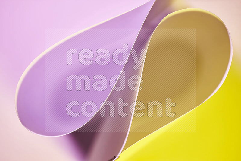 An abstract art of paper folded into smooth curves in yellow and pink gradients