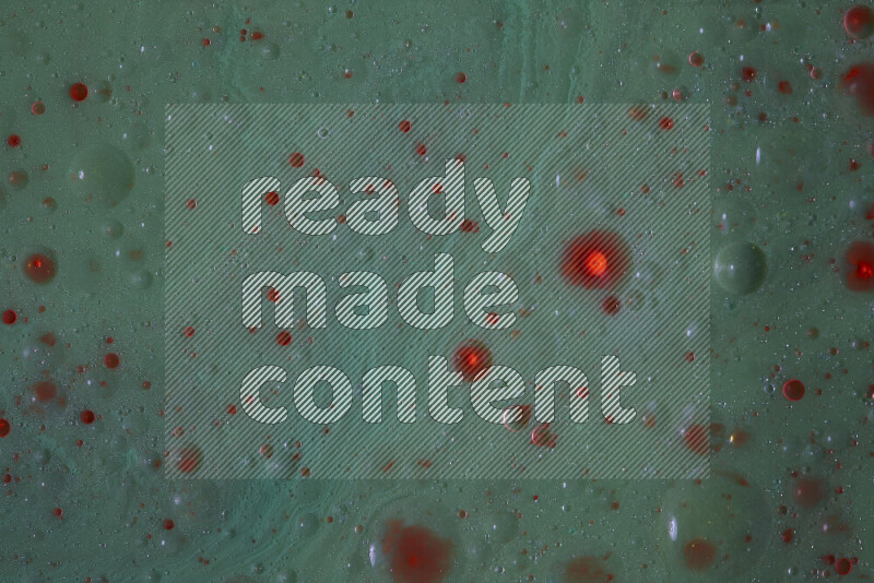 The image captures a dramatic splatter of red paint over a green backdrop