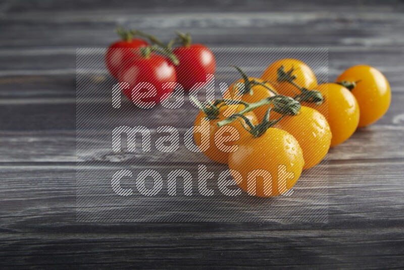 Mixed cherry tomato veins on a textured grey wooden background 45 degree