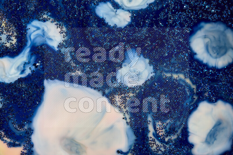 A close-up of sparkling blue glitter scattered on swirling blue and white background