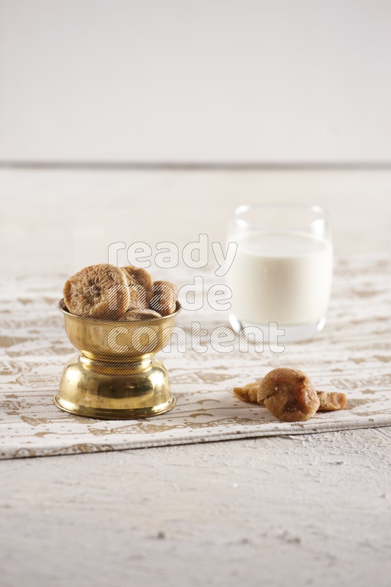 Dried fruits in a metal bowl with milk in a light setup