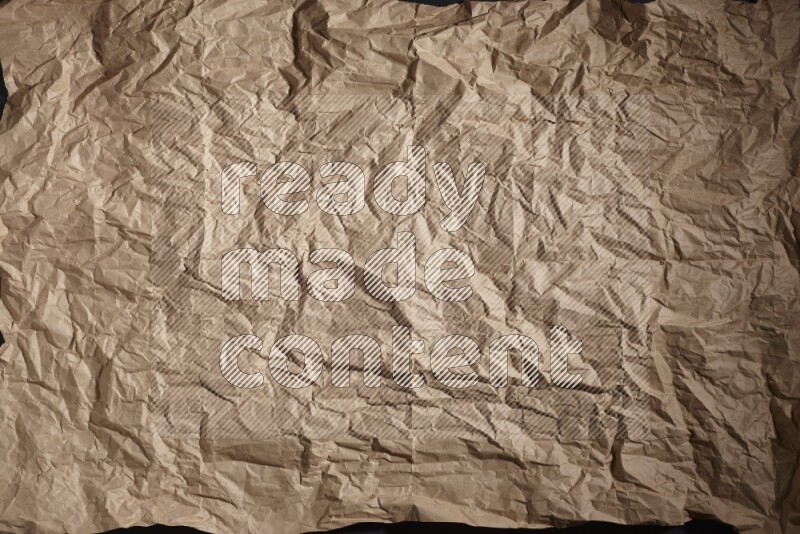 Crumpled craft paper on black background