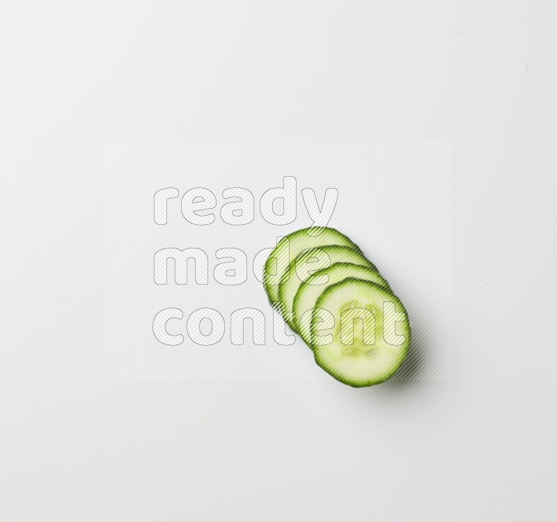Multiple cucumber slices on white background