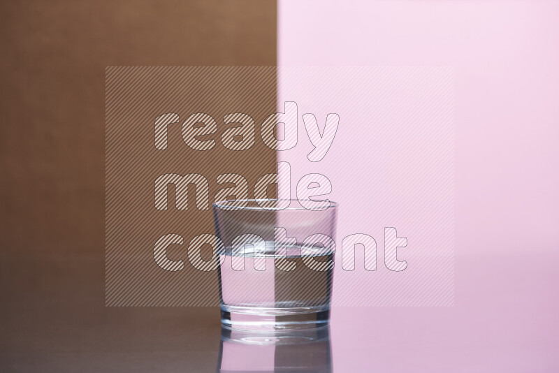 The image features a clear glassware filled with water, set against brown and rose background