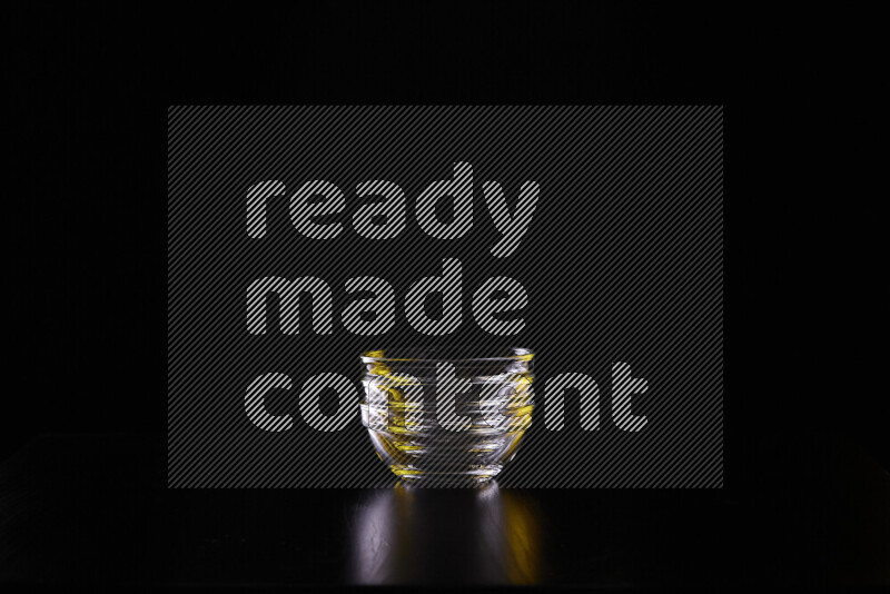 Glassware with rim light in yellow and white against black background