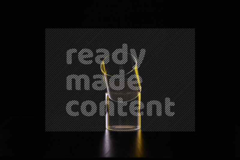 Glassware with rim light in yellow and white against black background