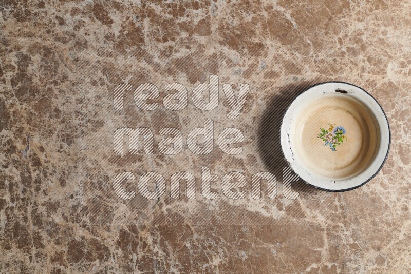 صحن معدني عتيق على خلفية من الرخام البيج