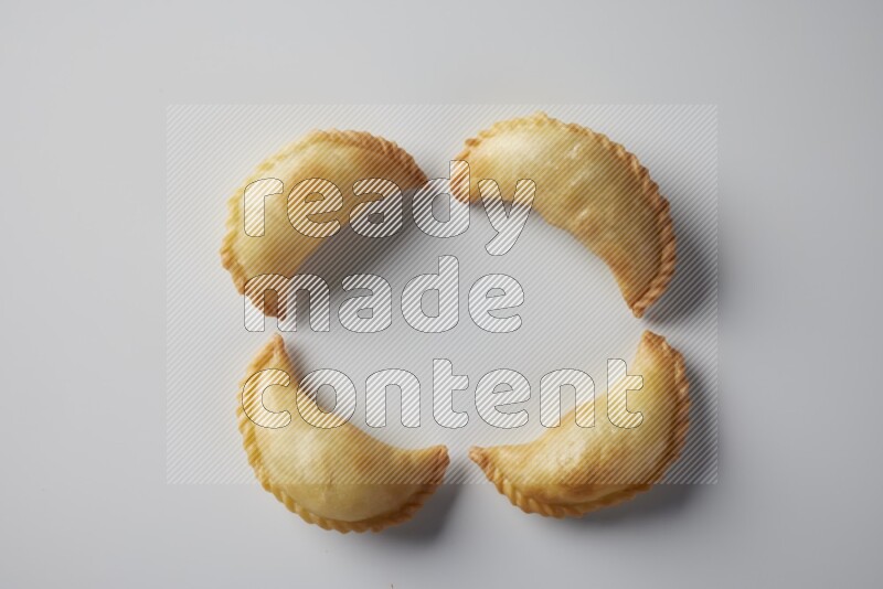 Four fried sambosa from a top angle on a white background