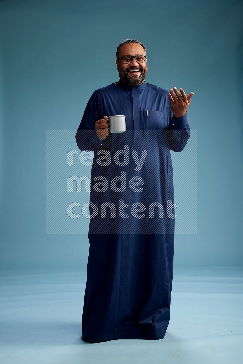 Saudi Man without shimag Standing drinking coffee on blue background