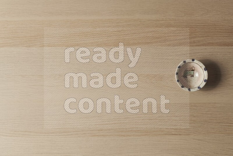 وعاء فخاري مزخرف على خلفية خشبية فاتحة