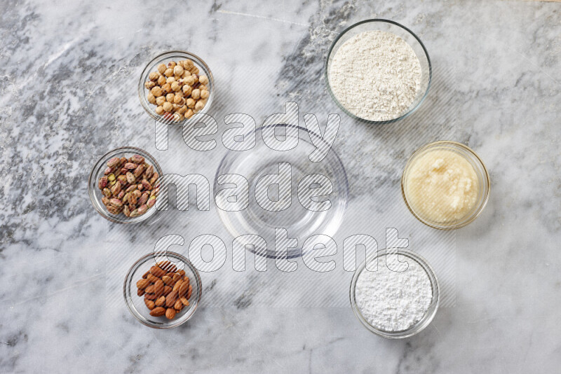 Ghoriba step by step with its ingredient, flour, powdered sugar, ghee and nuts on grey marble background