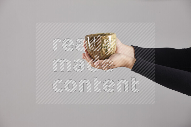 A woman in black abaya holding different pottery essentials in different positions