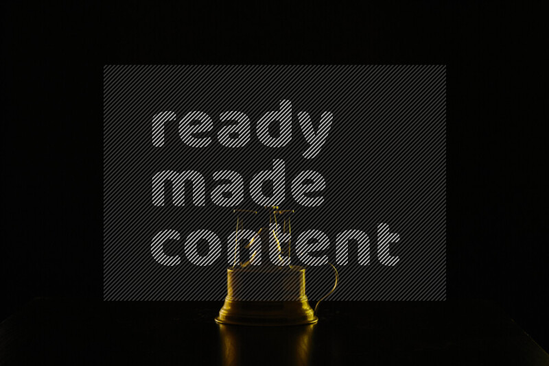 A turkish coffee maker with colored rim light against black background