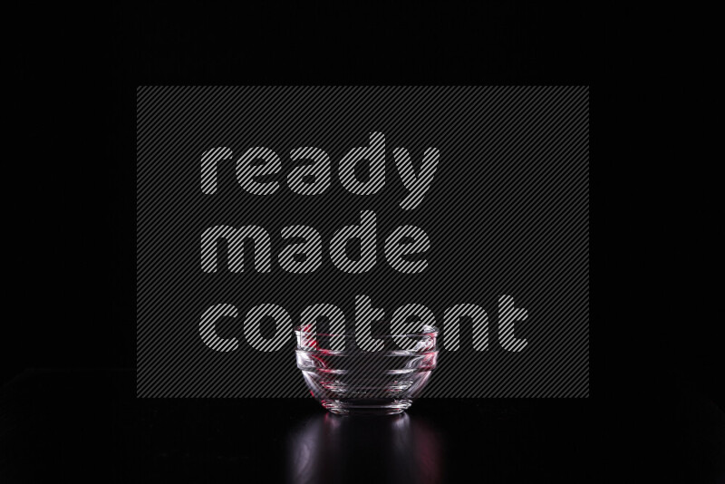 Glassware with rim light in red and white against black background