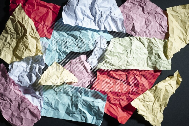 Crumpled multicolored paper on black background