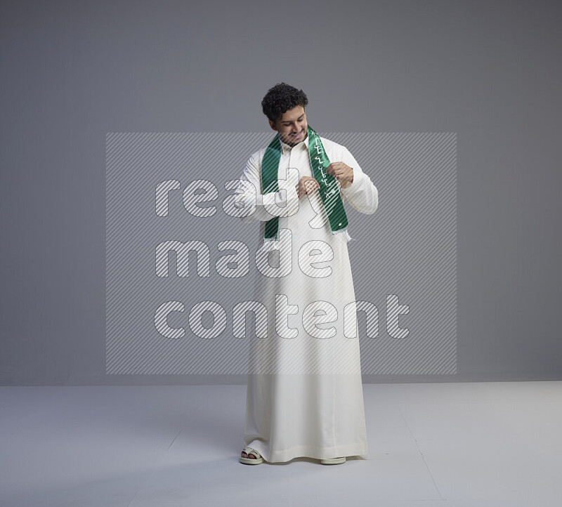 رجل سعودي يرتدي ثوب ابيض و شال يتفاعل مع الكاميرا