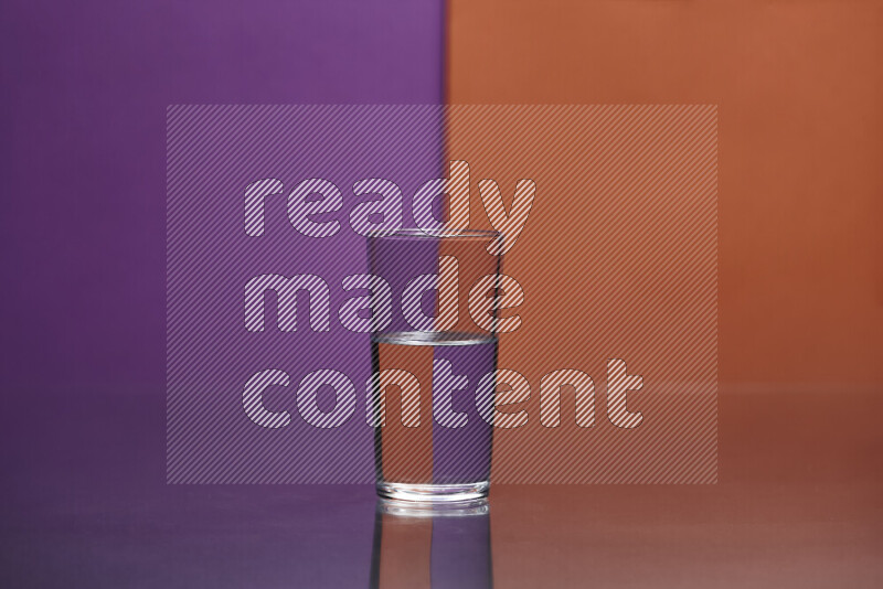 The image features a clear glassware filled with water, set against purple and dark orange background