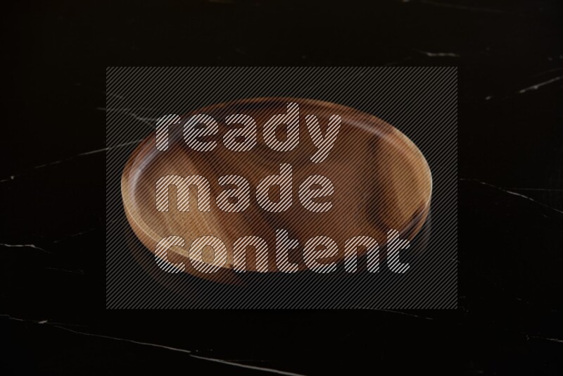 brown wood round plate on black marble countertop
