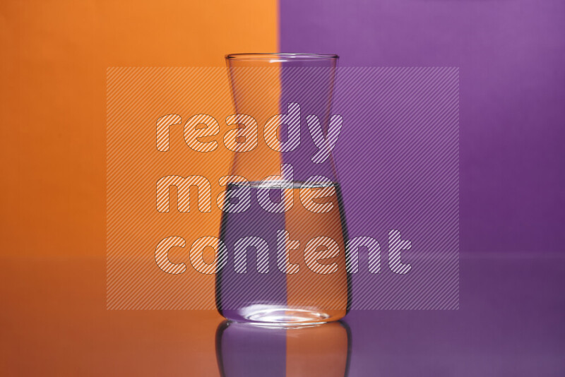 The image features a clear glassware filled with water, set against orange and purple background
