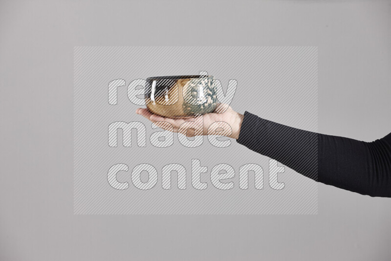 A woman in black abaya holding different pottery essentials in different positions