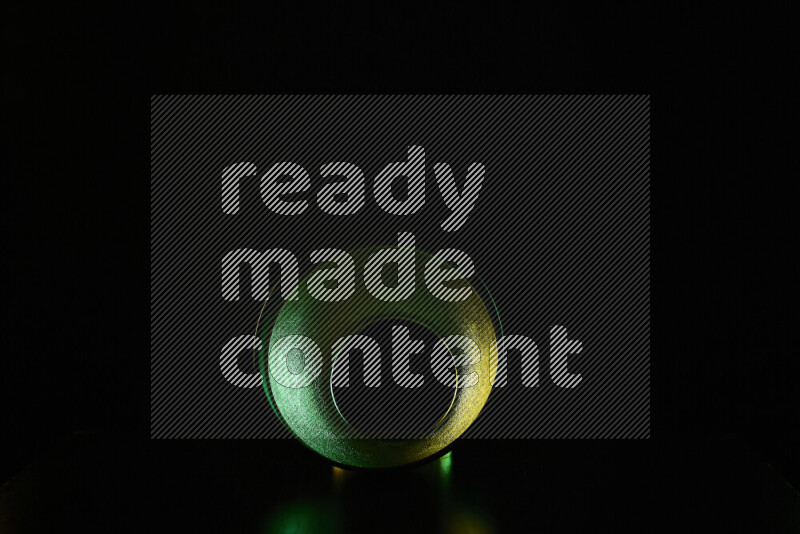 A reflector diffuser lamp shade dish with colored rim light against black background