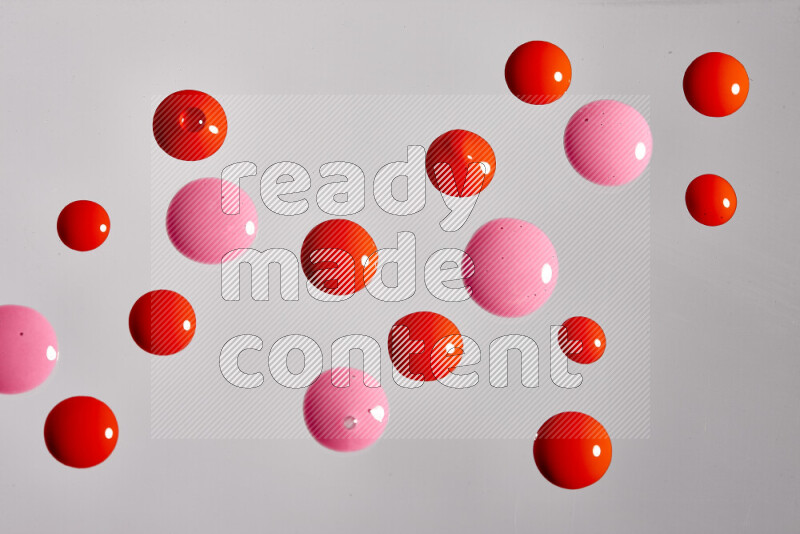 Close-ups of abstract pink and red paint droplets on the surface