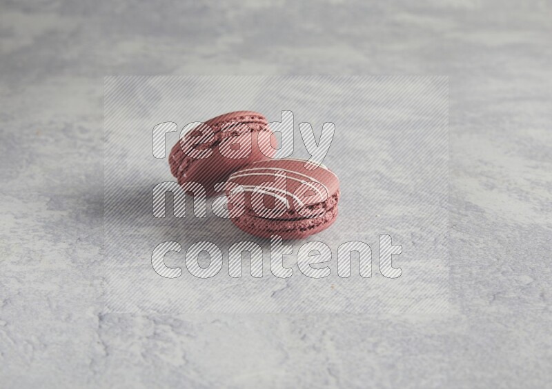 45º Shot of two Red Poppy Flower macarons on white  marble background
