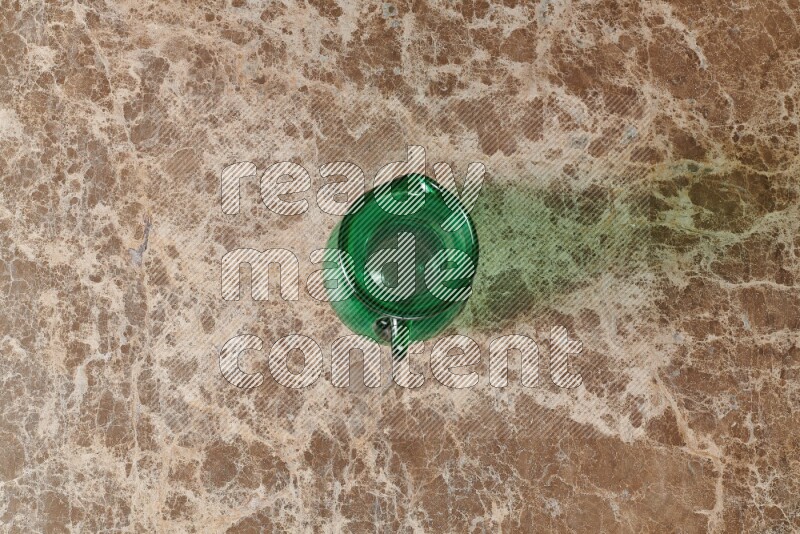 إبريق زجاجي فارغ على خلفية من الرخام البيج