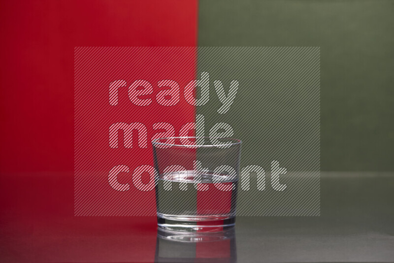 The image features a clear glassware filled with water, set against red and dark green background