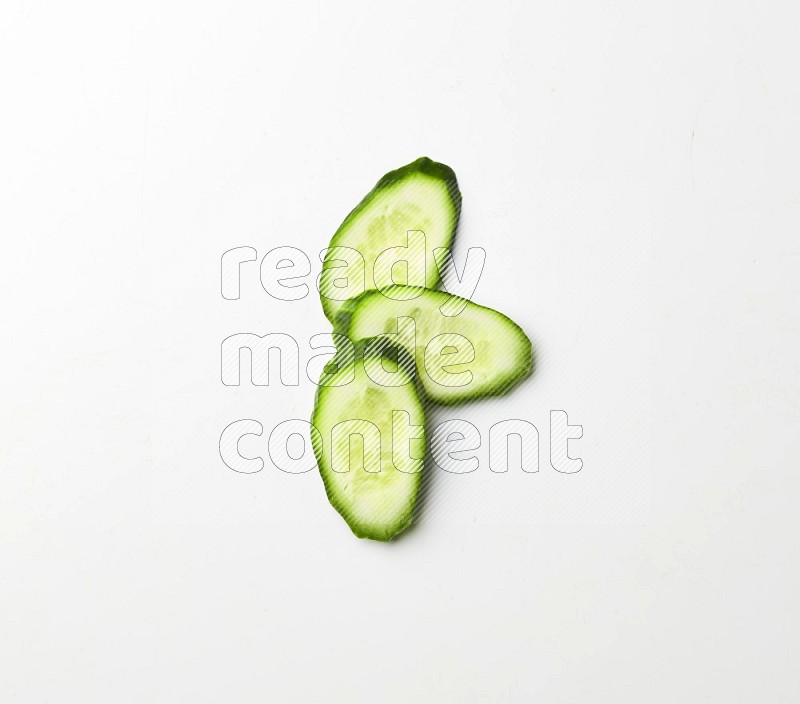 three cucumber slices on white background