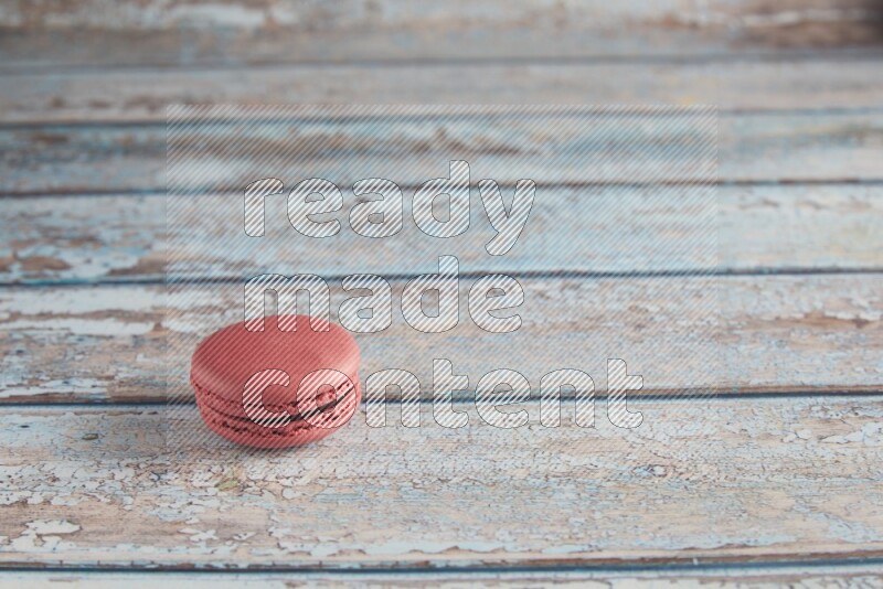 45º Shot of Pink Raspberry macaron on light blue wooden background
