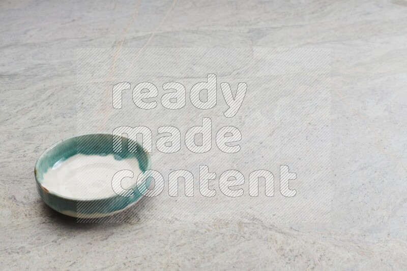 A multicolored pottery bowl on grey marble background