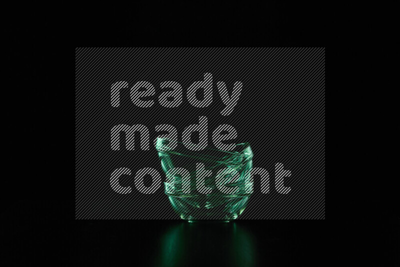 Glassware with rim light in green against black background