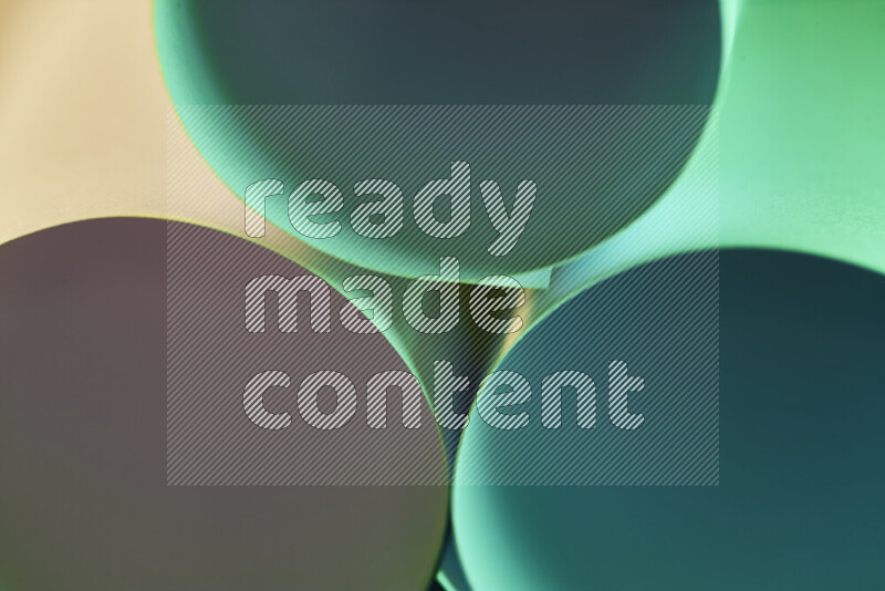 الصورة تعرض فن ورقي تجريدي بأشكال دائرية بدرجات متنوعة من اللون الأخضر والدرجات الدافئة