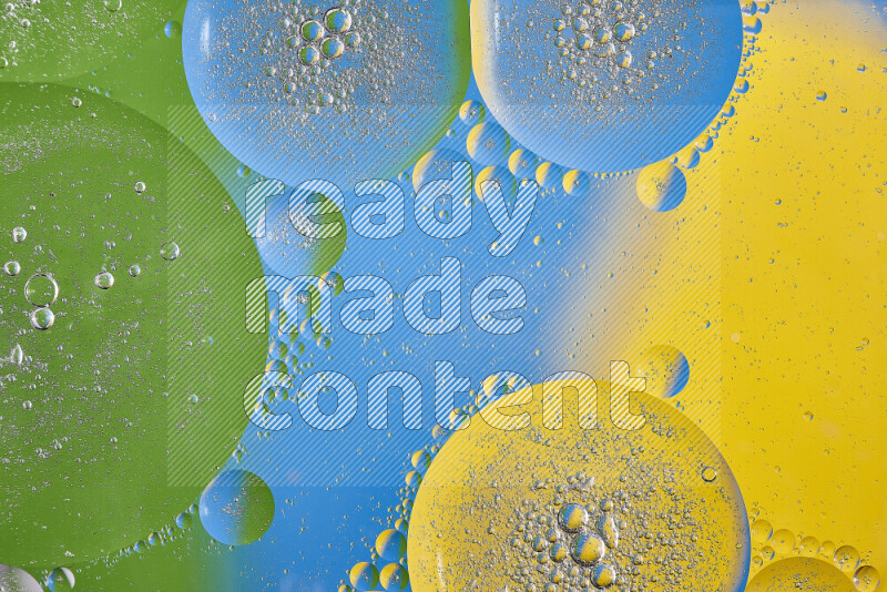 Close-ups of abstract oil bubbles on water surface in shades of yellow, green and blue