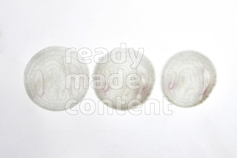 Onion slices on illuminated white background