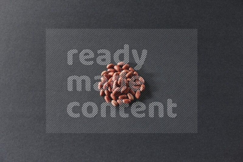 A bunch of red skin peanuts on a black background in different angles