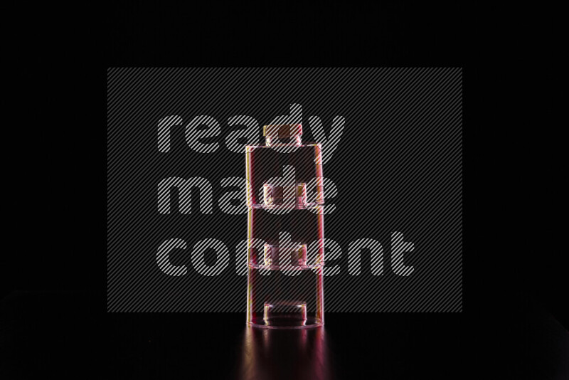 Glassware with rim light in red and yellow against black background