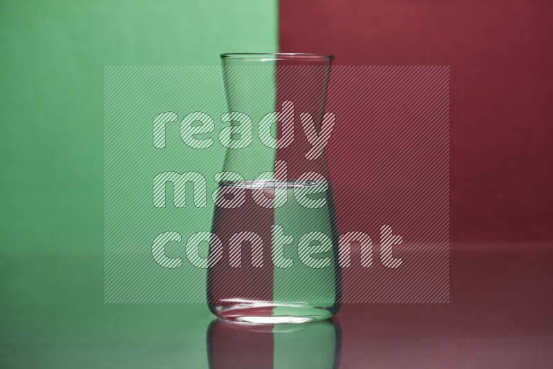 The image features a clear glassware filled with water, set against green and dark red background