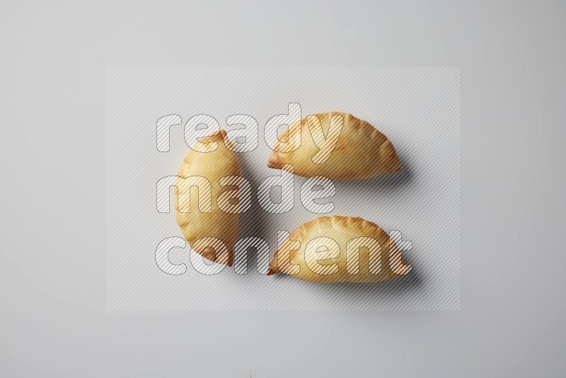 Three fried sambosa from a top angle on a white background
