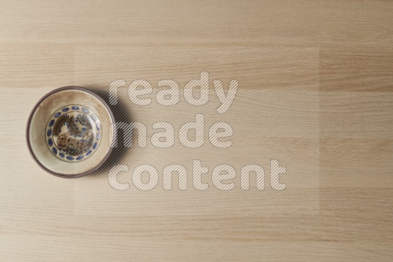 صحن فخاري مزخرف على خلفية خشبية فاتحة