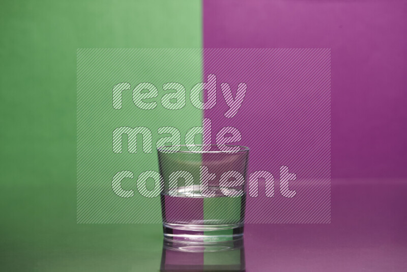 The image features a clear glassware filled with water, set against green and purple background