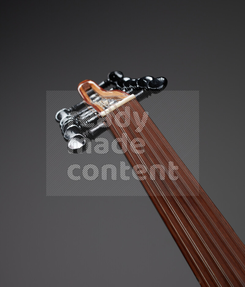 parts of a brown wooden Oud in a gray background