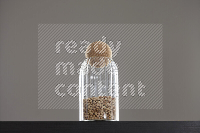 Black-eyed peas in a glass jar on black background