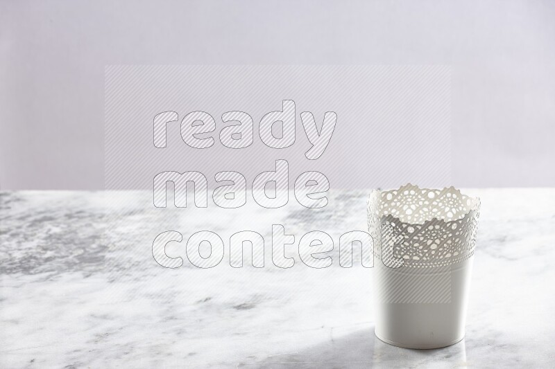 An empty white plant pot on grey marble background