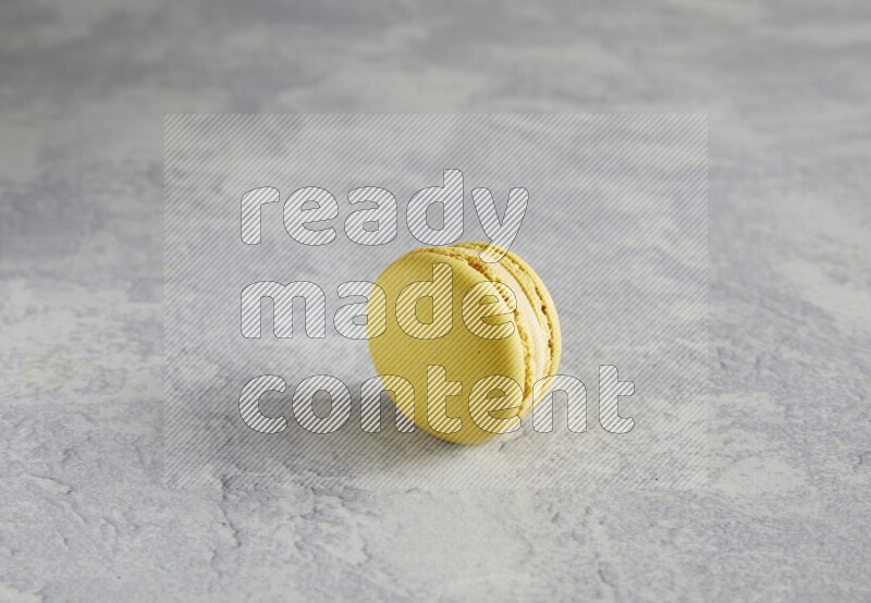 45º Shot of Yellow Lime macaron on white marble