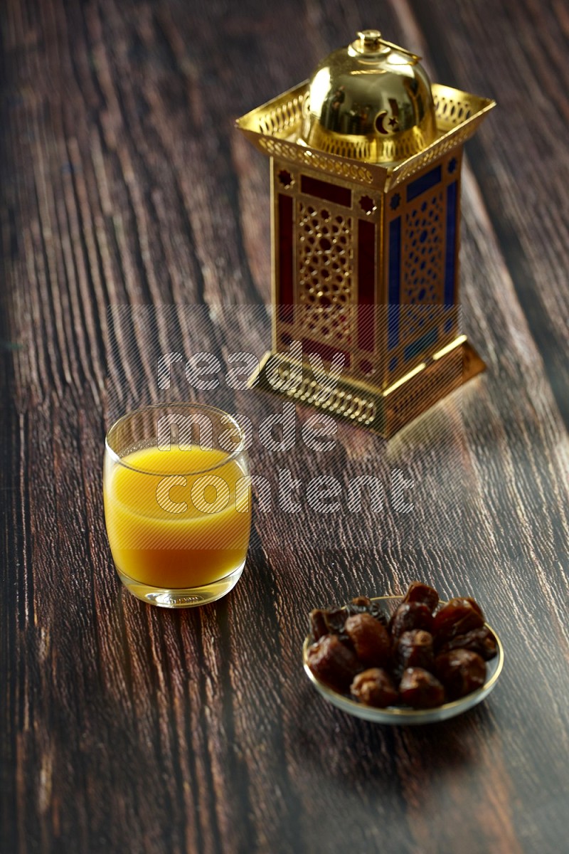 A golden lantern with different drinks, dates, nuts, prayer beads and quran on brown wooden background